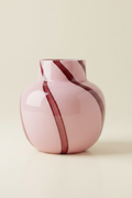 Pink glass vase with burgundy stripe detail on a plain cream background