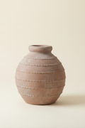 Ceramic vase with textured surface on a beige background